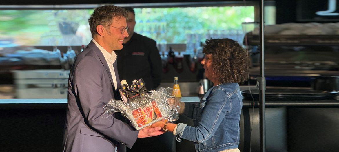 Carsten Höhler, der neue Leiter der Regionalen Diakonie Limburg-Weilburg, überreicht der bisherigen Leiterin, Irina Porada, einen Geschenkkorb.